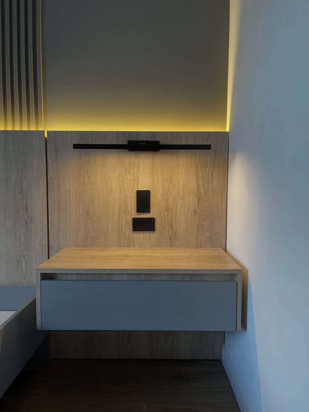 Custom floating media console with wood wall paneling and integrated lighting